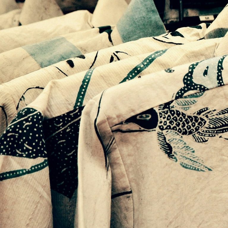 Fabric featuring intricate bird and floral patterns in muted tones.